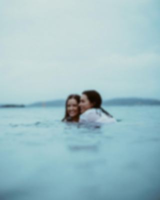 Two friends in still water, moody coastal frame