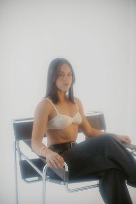 Seated on the wire chair, white studio set